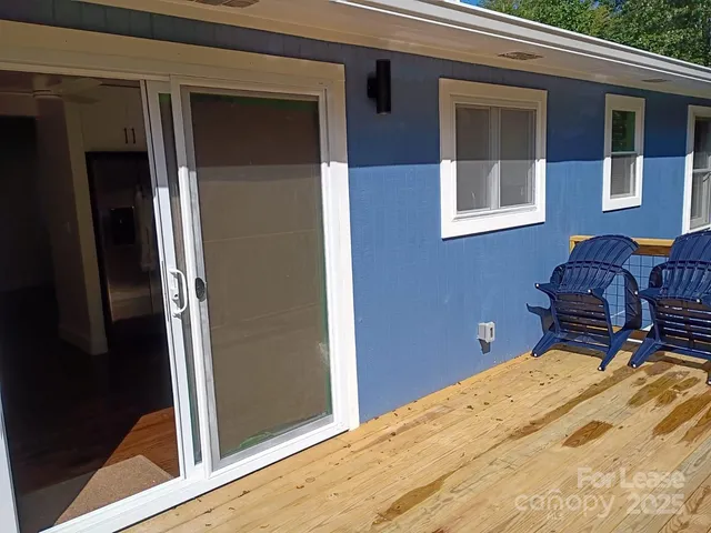a view of a backyard with a chair and the door