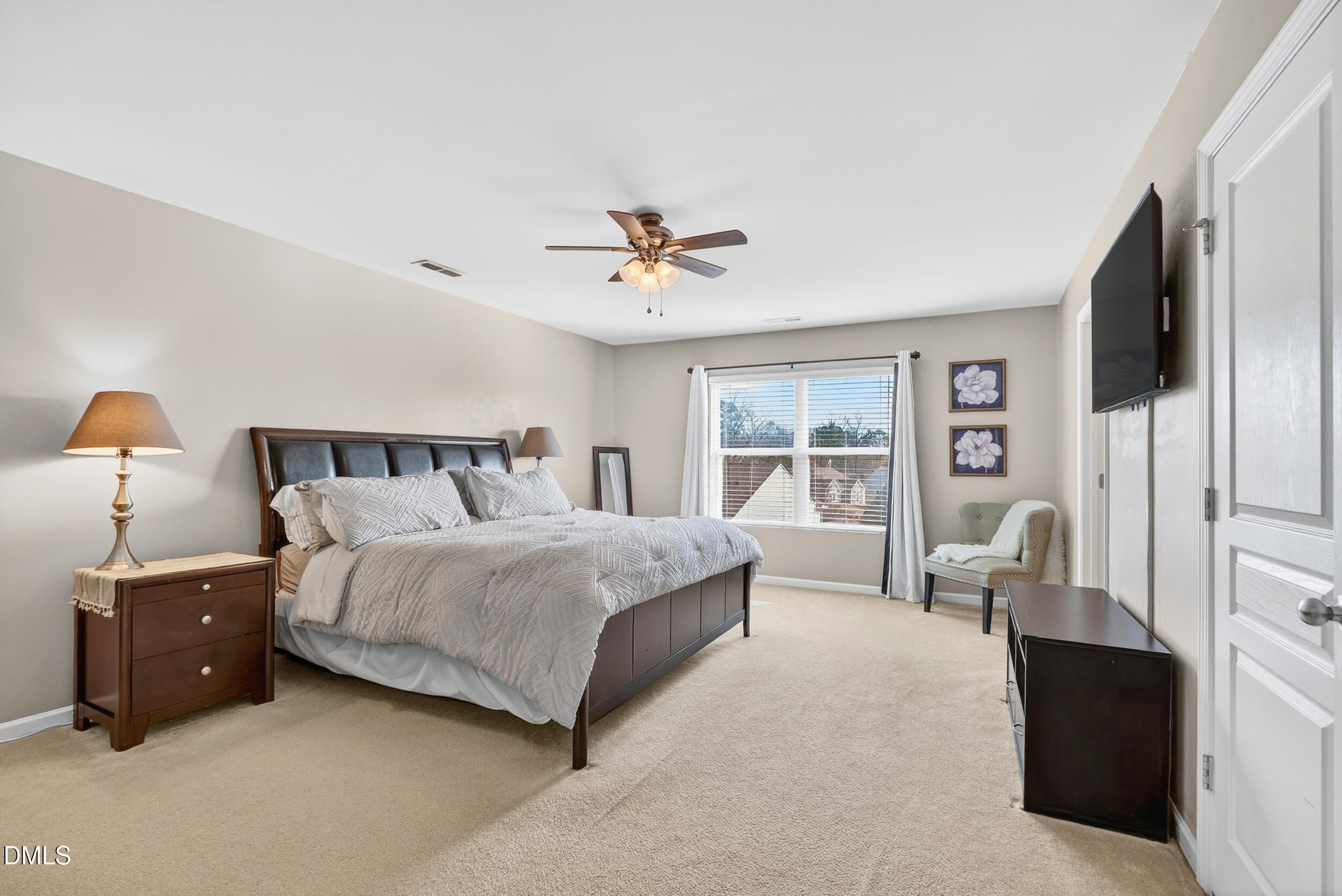 8144 Hovingham Way Raleigh, NC 27616 - Photo 14 of 37 a bedroom with a large bed and a chandelier