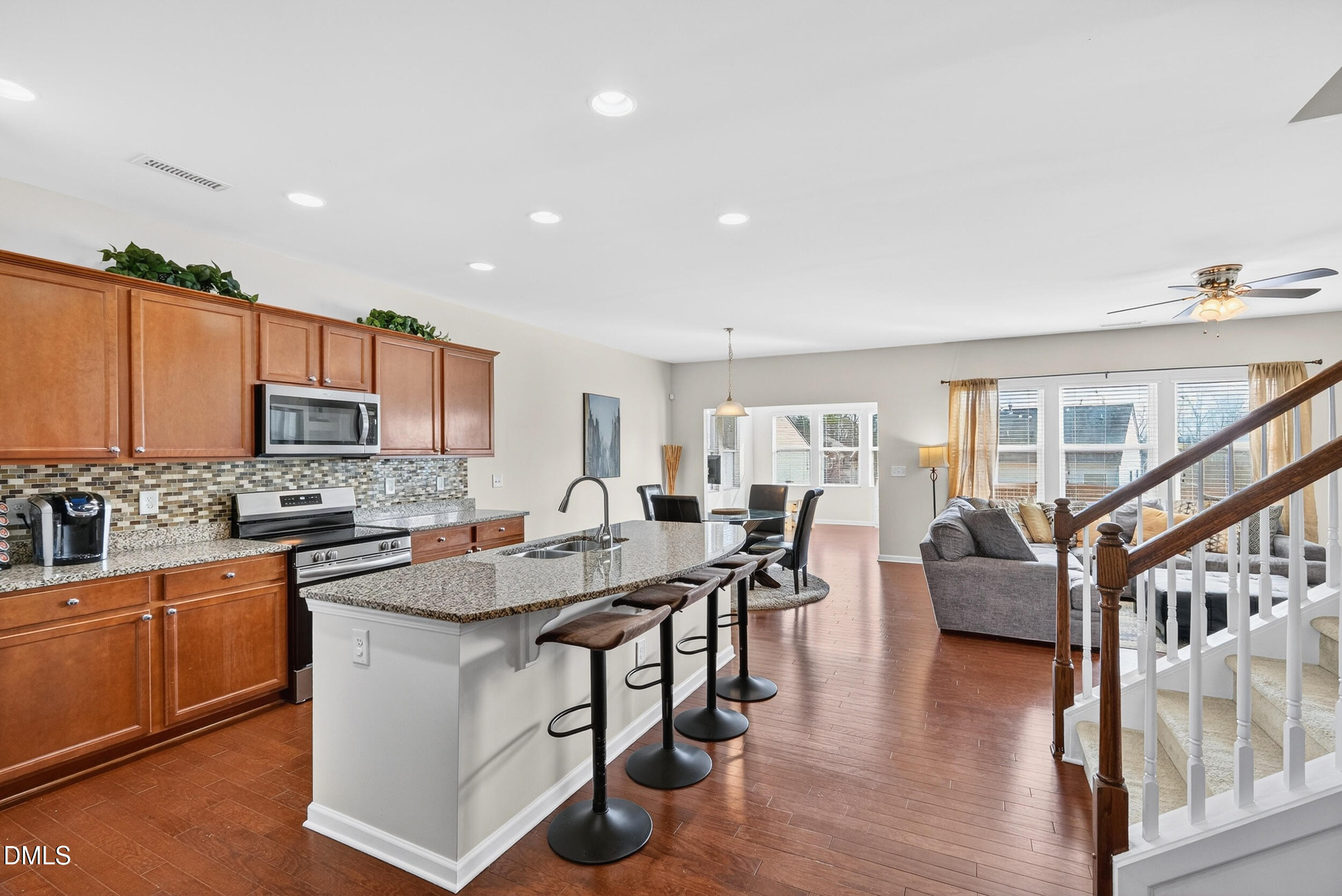 8144 Hovingham Way Raleigh, NC 27616 - Photo 4 of 37 a kitchen with stainless steel appliances granite countertop a stove top oven a sink dishwasher a dining table and chairs with wooden floor