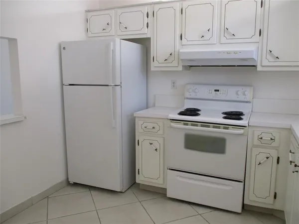 a kitchen with white cabinets and white appliances