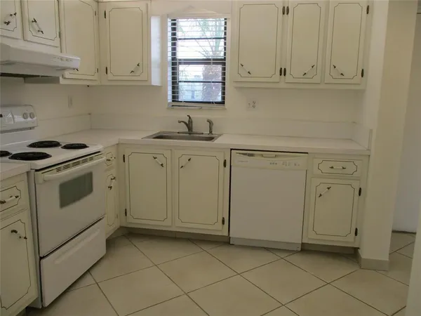 a kitchen with white cabinets and white appliances