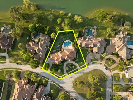 an aerial view of residential houses with outdoor space and lake view