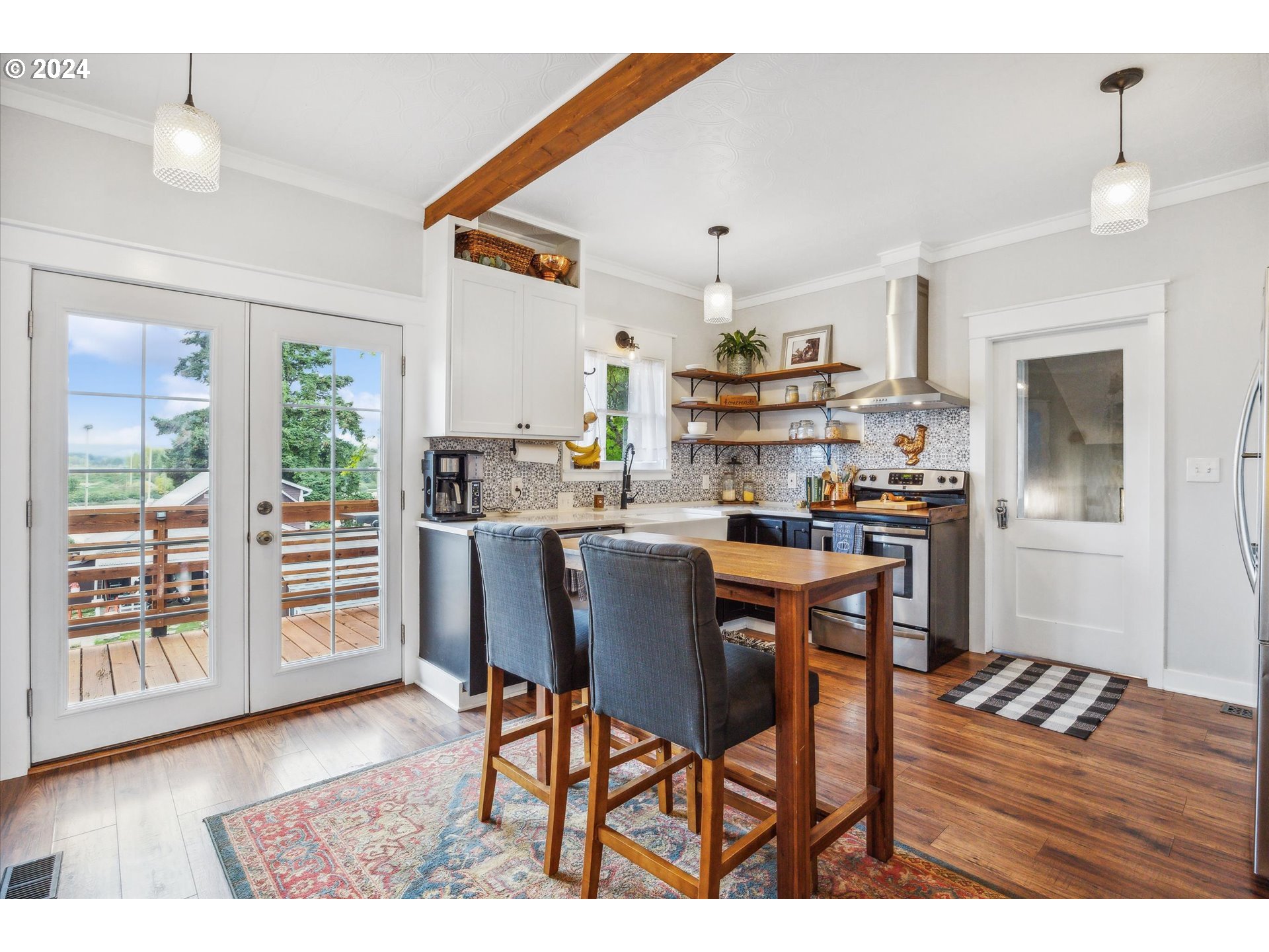 413 North 1st Avenue Ridgefield, WA 98642 - Photo 14 of 36 a kitchen with stainless steel appliances granite countertop a refrigerator a microwave oven a stove and a dining table with wooden floor