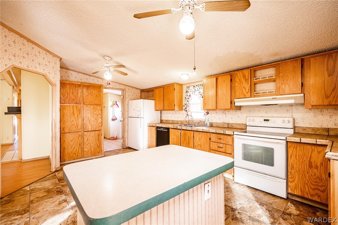 4496 Cowlic Road Golden Valley, AZ 86413 - Photo 5 of 50 a kitchen with a stove a sink and a refrigerator
