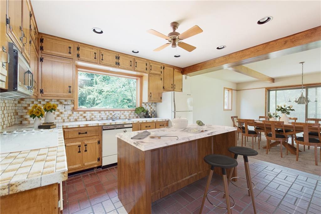 709 Camp Meeting Road Sewickley, PA 15143 - Photo 5 of 18 a large kitchen with kitchen island a sink a stove a dining table and chairs with wooden floor