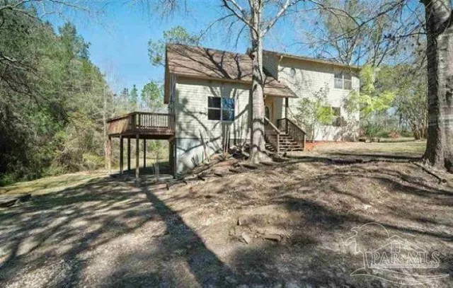 a view of house with backyard and trees