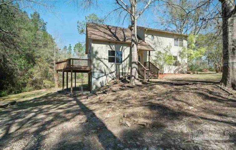 9543 Quiet Creek Road Milton, FL 32570 - Photo 2 of 16 a view of house with backyard and trees