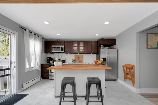 a dining hall with stainless steel appliances a dining table and chairs