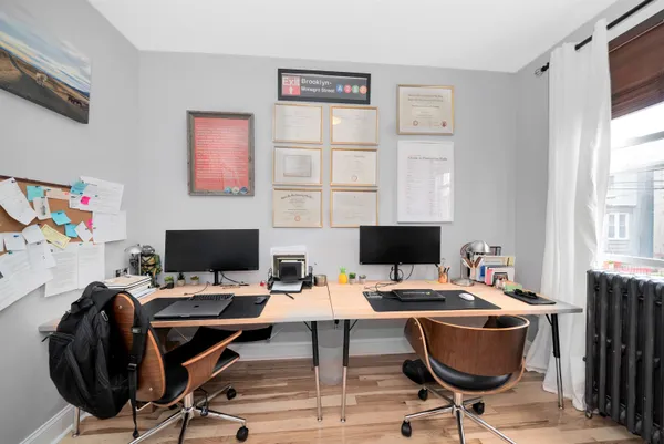 a view of a workspace with furniture and a window