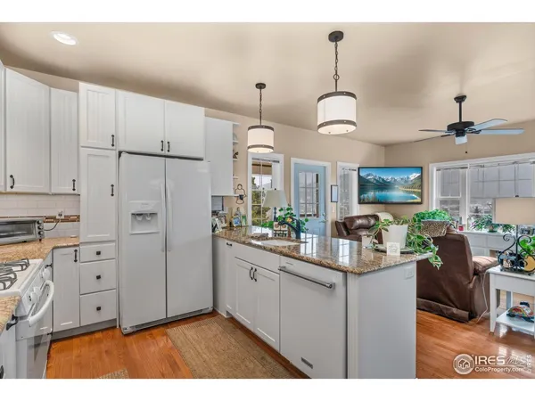 a kitchen with kitchen island granite countertop a sink cabinets and wooden floor