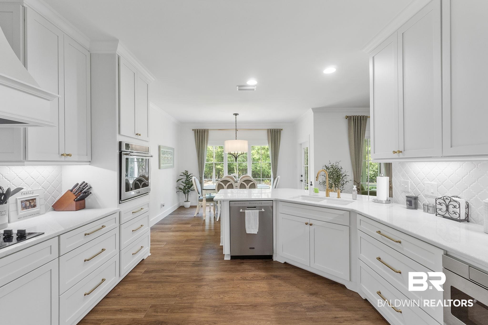 4451 Millhouse Road Gulf Shores, AL 36542 - Photo 18 of 50 Kitchen featuring tasteful backsplash, white cabinets, dark hardwood / wood-style flooring, stainless steel appliances, and sink