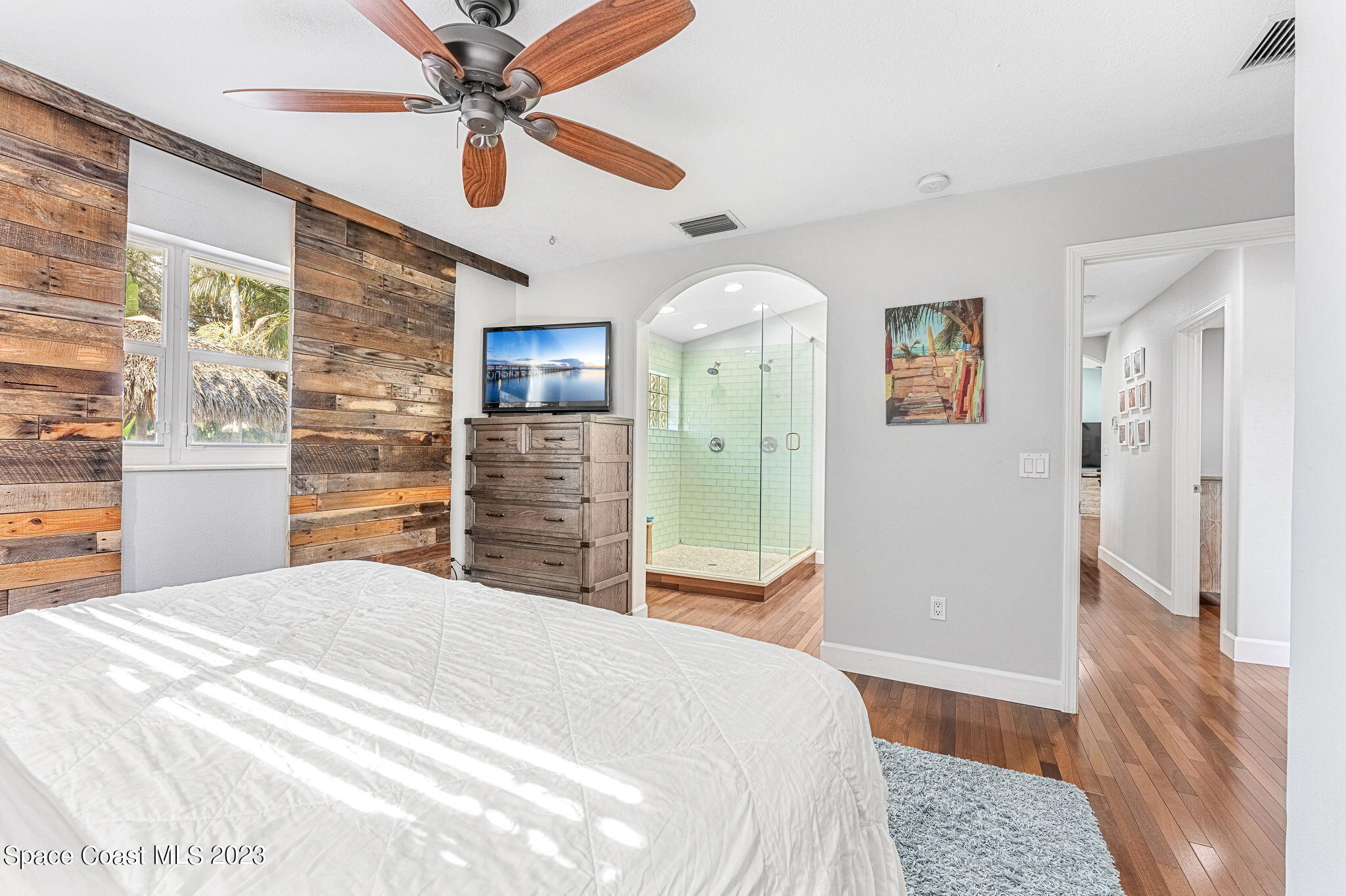 425 Cinnamon Drive Satellite Beach, FL 32937 - Photo 27 of 55 a bedroom with a bed a dresser and a chandelier