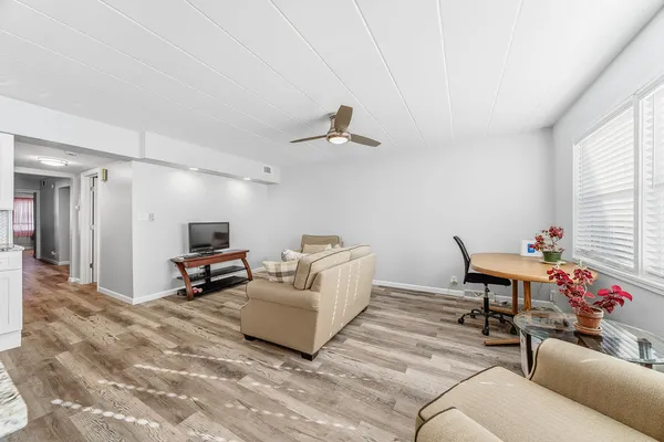 a living room with furniture a flat screen tv and a window