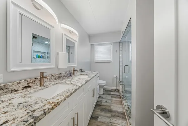 a bathroom with a granite countertop sink a mirror and a bathtub