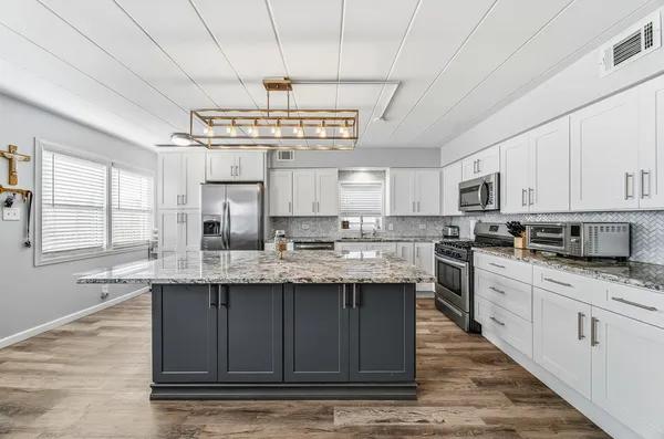 a kitchen with stainless steel appliances granite countertop a refrigerator and a sink