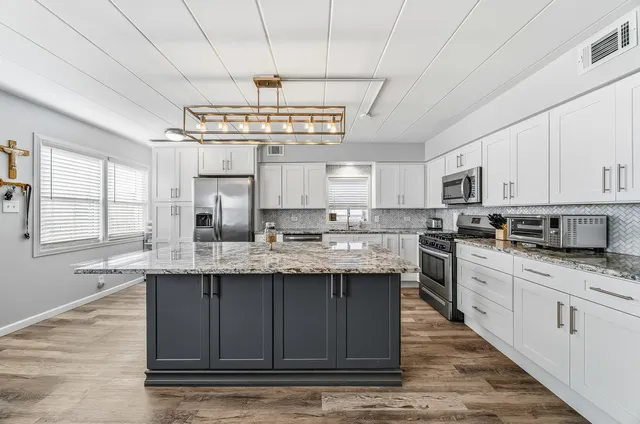a kitchen with stainless steel appliances granite countertop a refrigerator and a sink