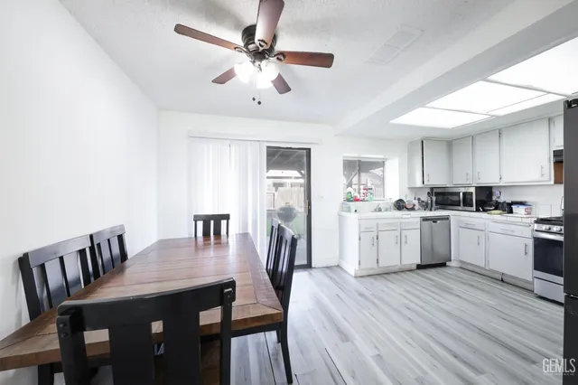 a kitchen with a dining table chairs refrigerator and cabinets