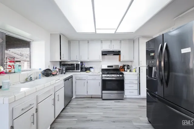 a kitchen with a sink stainless steel appliances and cabinets