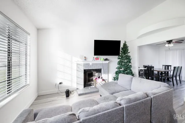 a living room with furniture a fireplace and a flat screen tv