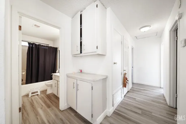 a kitchen with white cabinets and sink