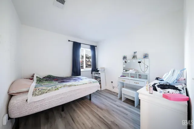 a bedroom with a bed and wooden floor