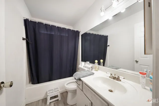 a bathroom with a sink vanity mirror and toilet