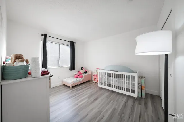 a bedroom with baby crib and a window