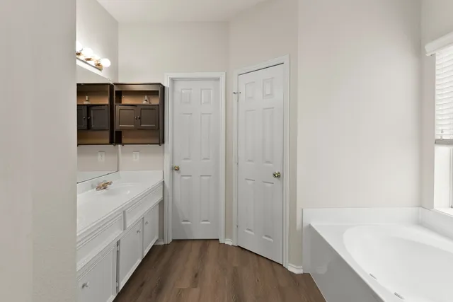 a bathroom with a sink a tub and a mirror