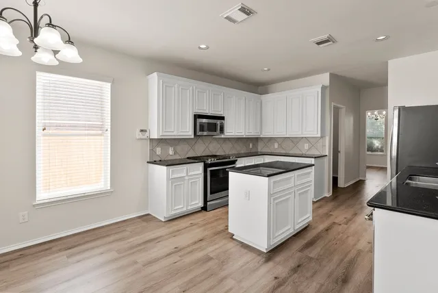 a kitchen with a stove window and a refrigerator