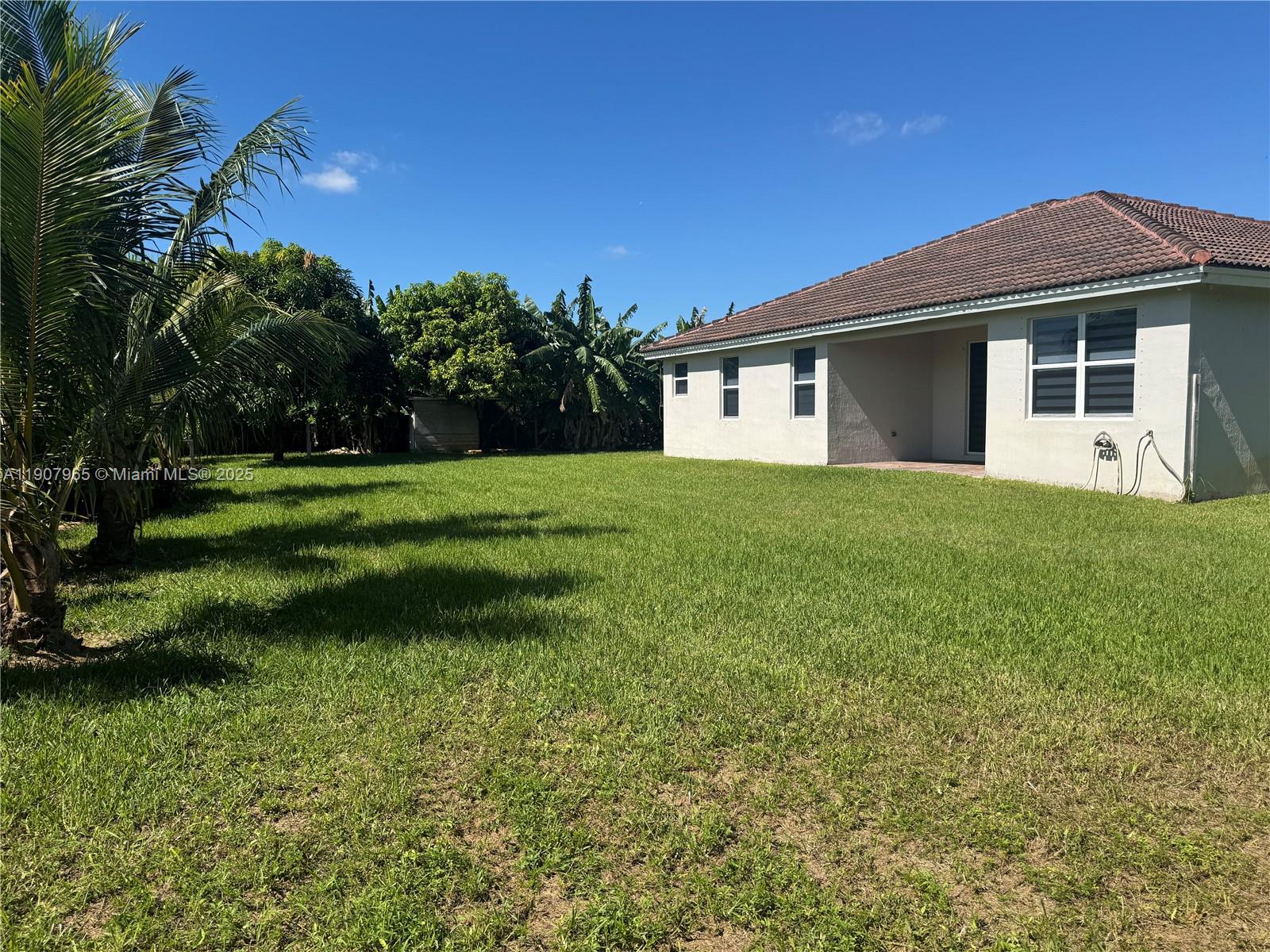 12800 Southwest 222nd Street Miami, FL 33170 - Photo 5 of 19 a front view of a house with a yard