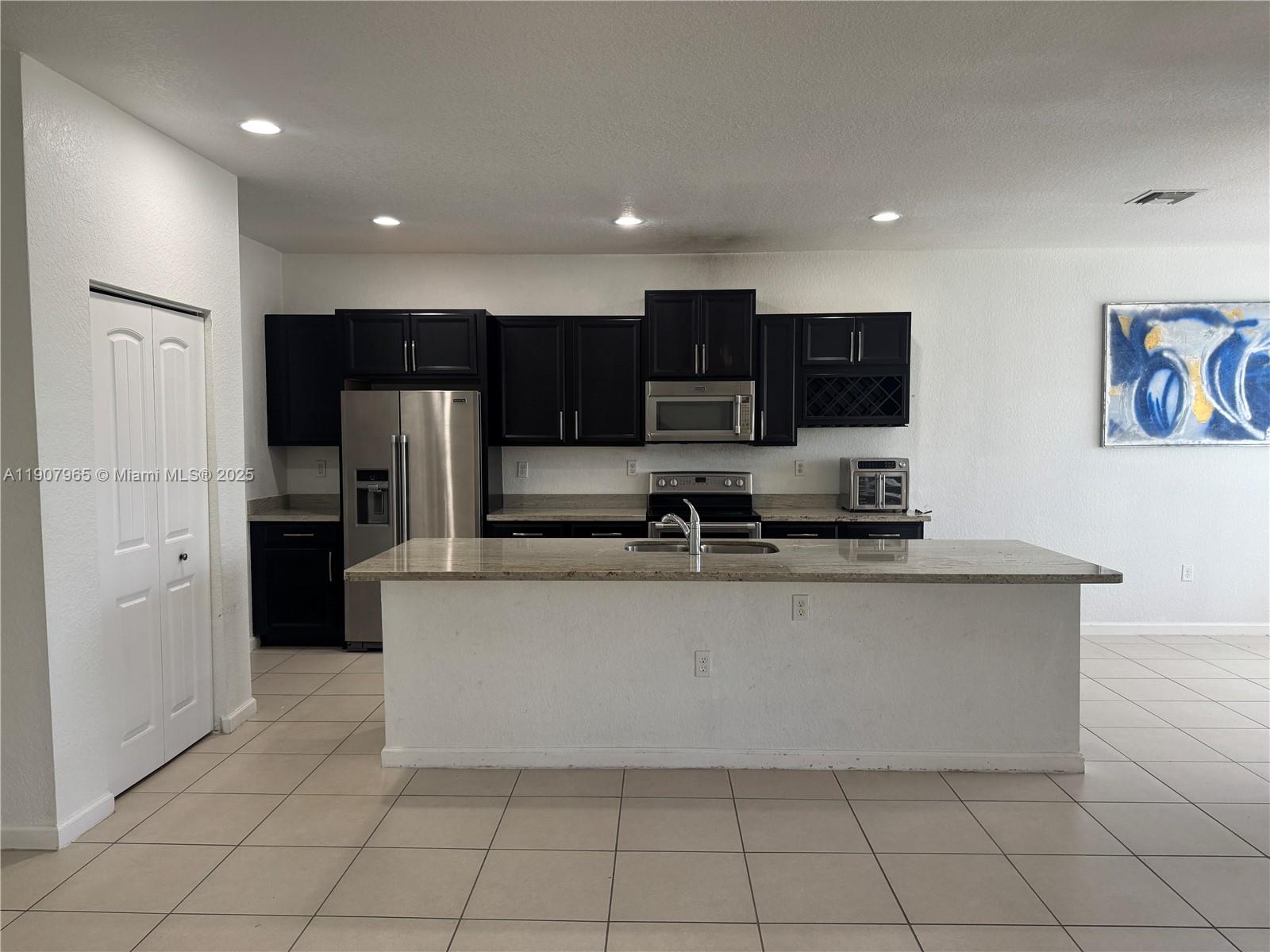 12800 Southwest 222nd Street Miami, FL 33170 - Photo 10 of 19 a large kitchen with stainless steel appliances a refrigerator and a microwave