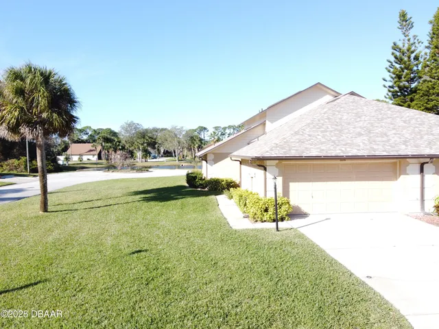 a view of a house with a yard and sitting area