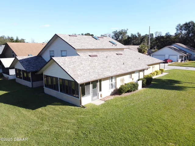 a aerial view of a house next to a yard with plants and trees
