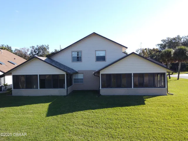 a white house with a tree in the background