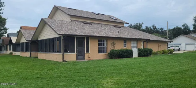a view of a house with brick walls and a yard with potted plants