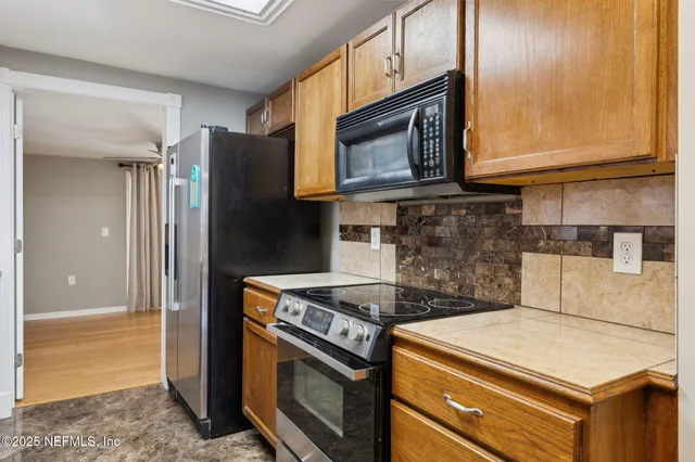 a kitchen with stainless steel appliances granite countertop a stove and a microwave