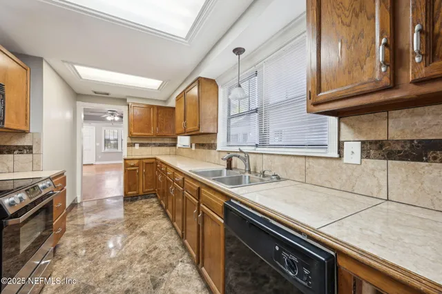a large kitchen with stainless steel appliances granite countertop a sink and cabinets