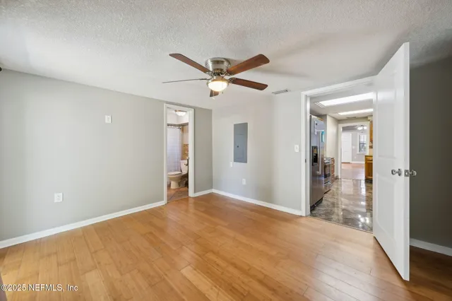 a view of a big room with wooden floor and a ceiling fan
