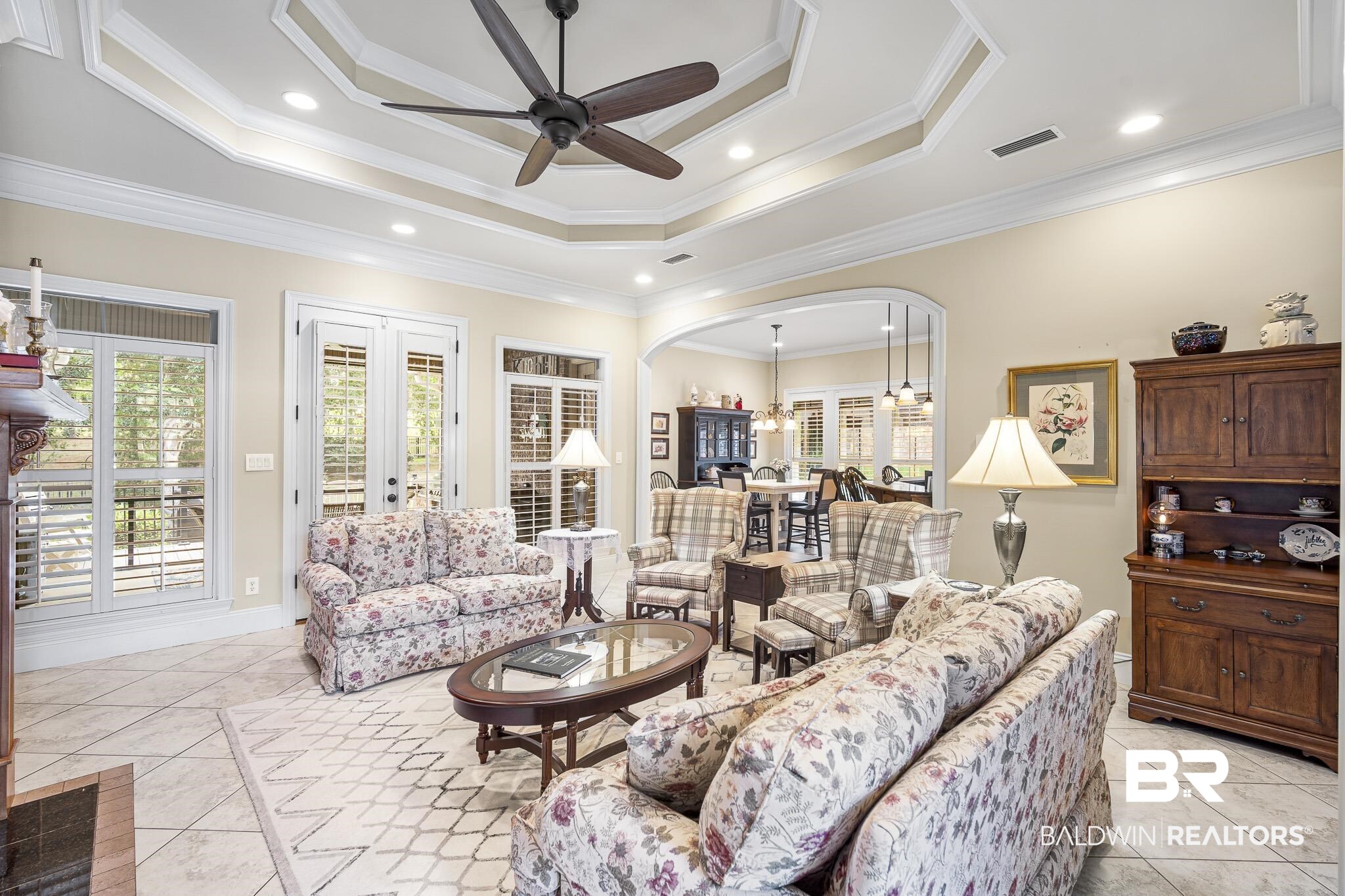 7090 Carson Lane Daphne, AL 36527 - Photo 6 of 37 Living room with ceiling fan, a raised ceiling, light tile patterned floors, and ornamental molding