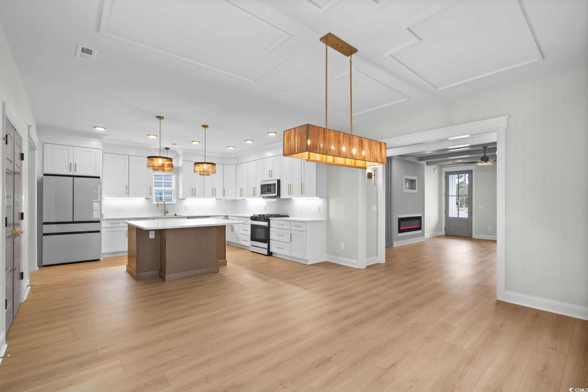 148 Arbor Ridge Circle Conway, SC 29526 - Photo 37 of 37 Kitchen featuring white cabinetry, freestanding refrigerator, pendant lighting, open floor plan, and a kitchen island