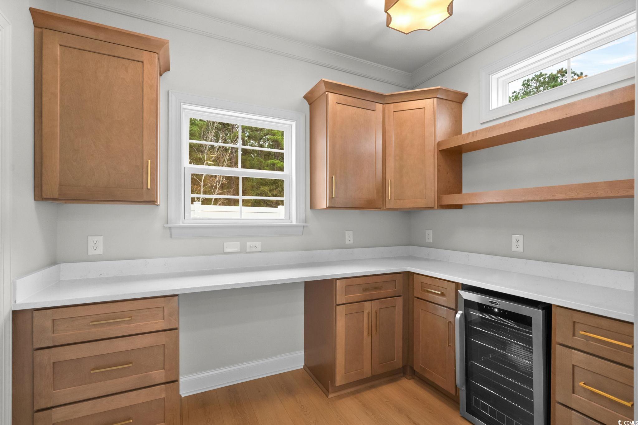 148 Arbor Ridge Circle Conway, SC 29526 - Photo 13 of 37 Kitchen with plenty of natural light, beverage cooler, brown cabinetry, open shelves, and ornamental molding