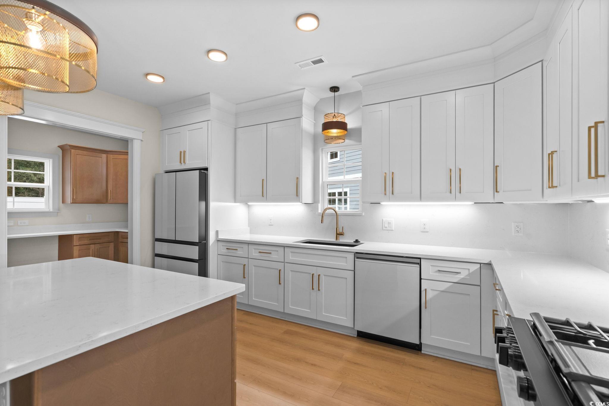 148 Arbor Ridge Circle Conway, SC 29526 - Photo 18 of 37 Kitchen with hanging light fixtures, appliances with stainless steel finishes, light stone countertops, light wood-type flooring, and recessed lighting