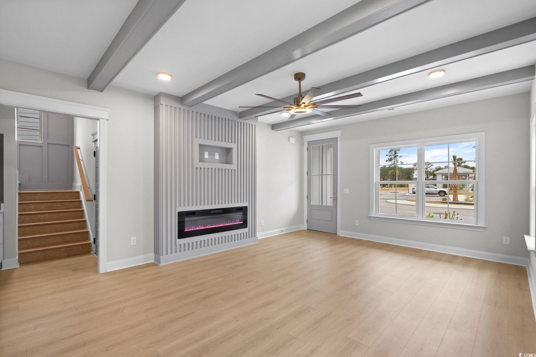 148 Arbor Ridge Circle Conway, SC 29526 - Photo 8 of 37 Unfurnished living room featuring beam ceiling, stairs, ceiling fan, a glass covered fireplace, and light wood-style floors