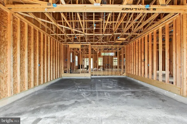 a view of an empty room with wooden floor and windows