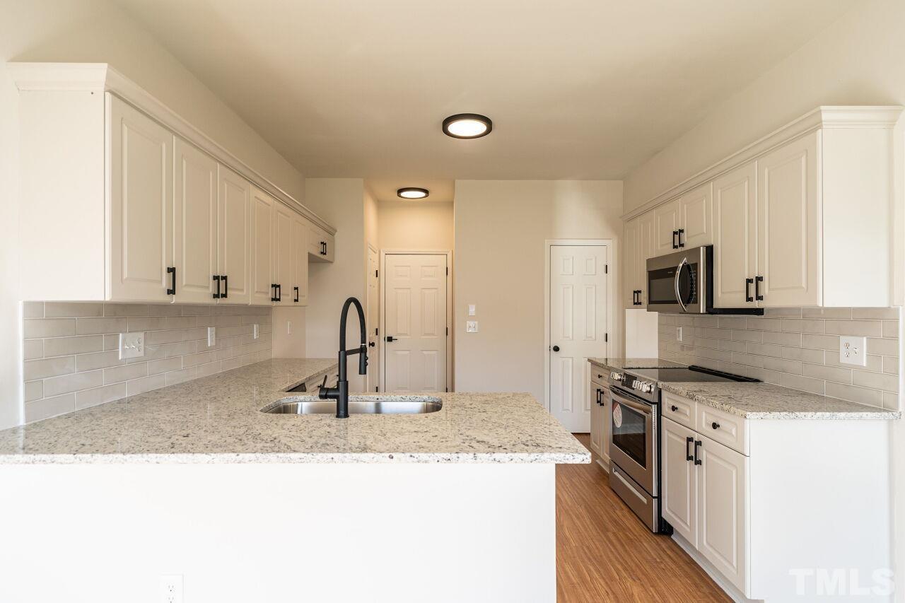 4204 Beacon Crest Way Raleigh, NC 27604 - Photo 14 of 29 a kitchen with stainless steel appliances granite countertop a sink stove and refrigerator