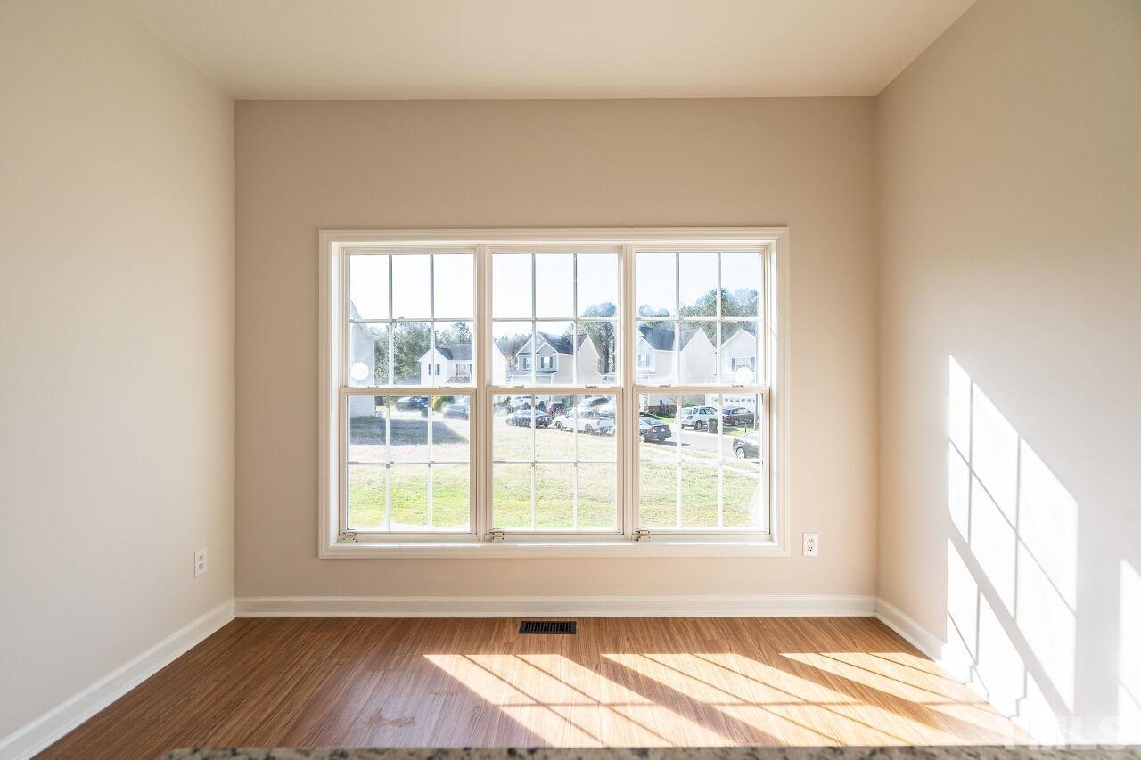 4204 Beacon Crest Way Raleigh, NC 27604 - Photo 10 of 29 a view of an empty room with wooden floor and a window
