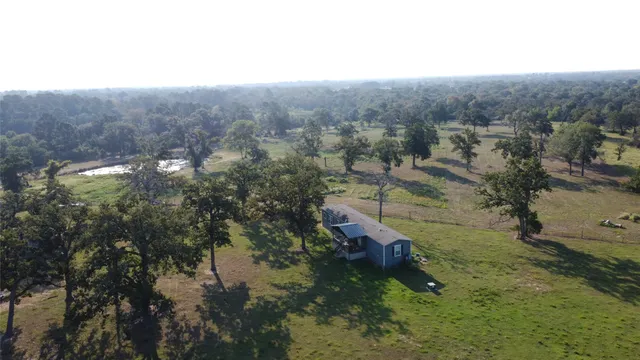 an aerial view of a house with a yard and sitting area