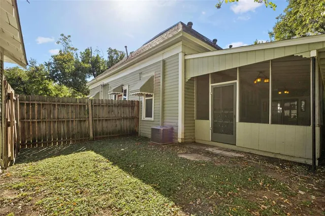 a view of a house with a small yard and wooden fence