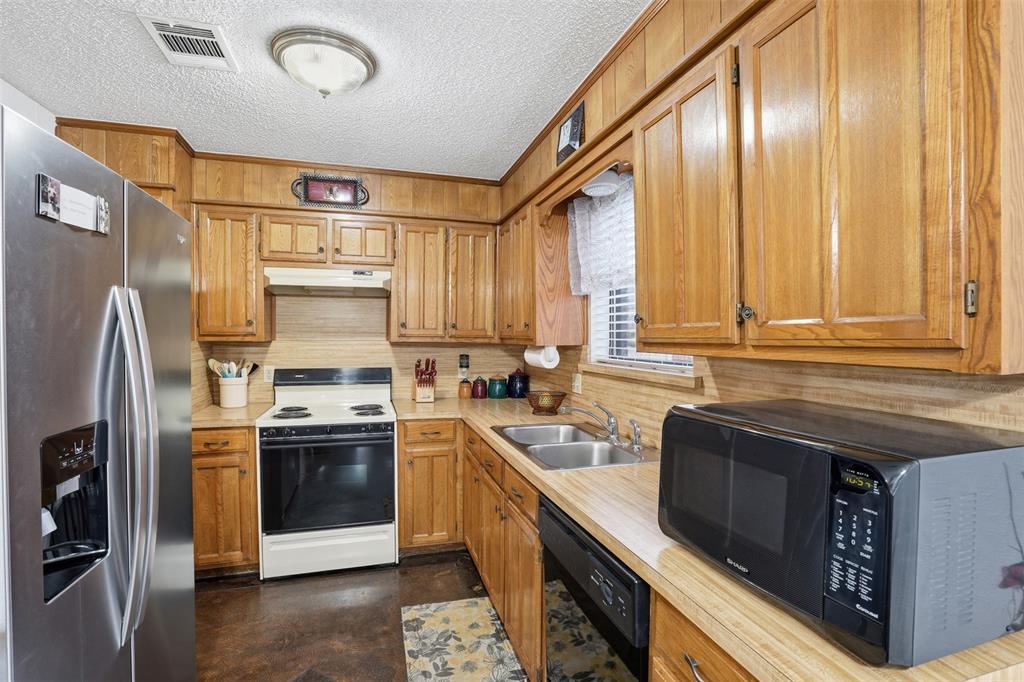 6437 High Lawn Terrace Watauga, TX 76148 - Photo 11 of 21 a kitchen with stainless steel appliances granite countertop a stove a sink and a refrigerator
