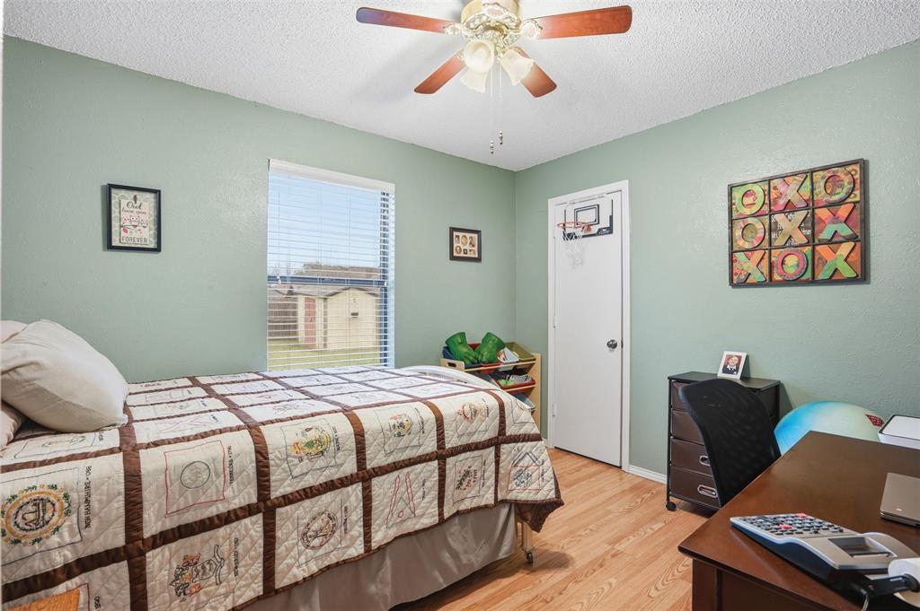 6437 High Lawn Terrace Watauga, TX 76148 - Photo 16 of 21 a bedroom with a bed and wooden floor